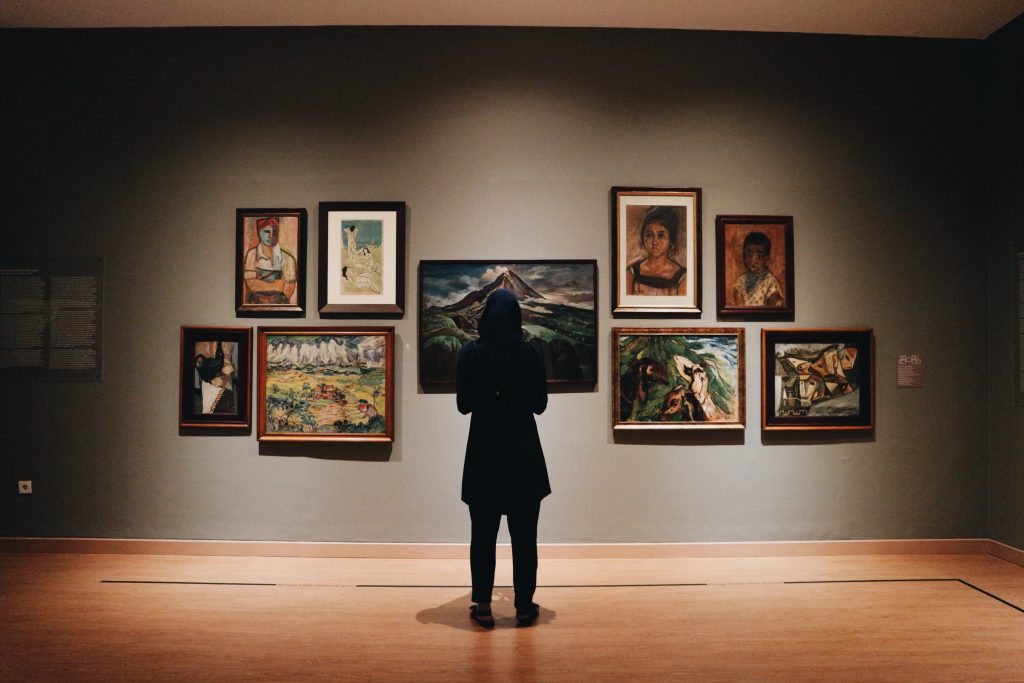 woman in art gallery looking at paintings